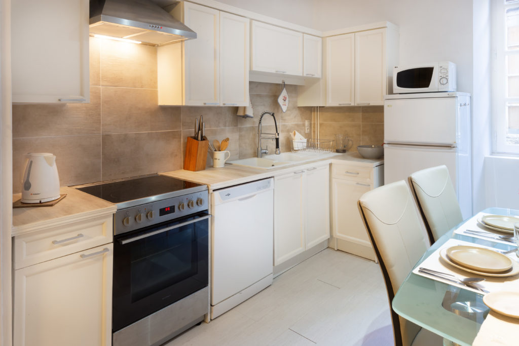 La cuisine aménagée du Logis à Sarlat, avec four, plaques et lave-vaisselle