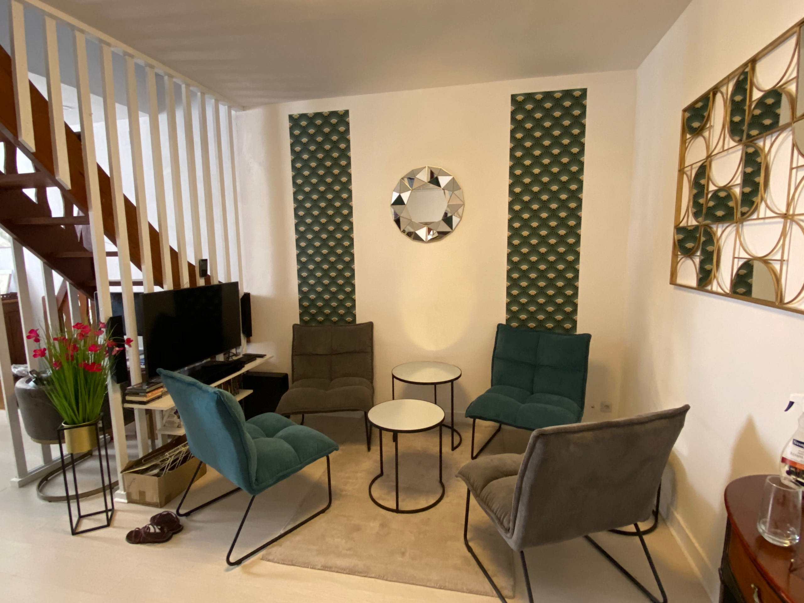 Le Salon Vert du Logis à Sarlat, fauteuils verts et escalier menant aux chambres